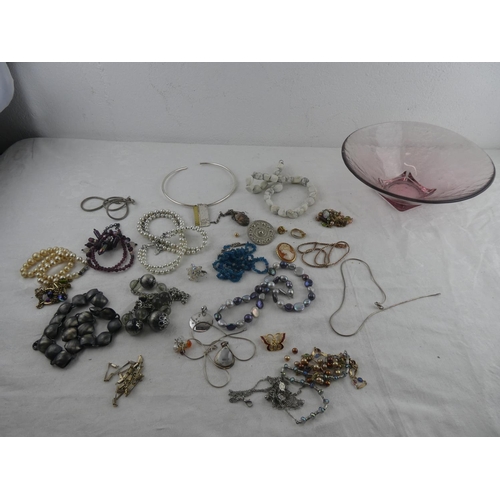 110 - An assortment of various costume jewellery in studio glass dish.