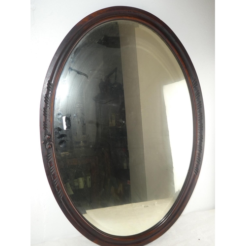 228 - A large oval framed mirror.