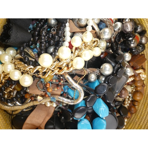 231 - A large assortment of costume jewellery in a wicker basket.