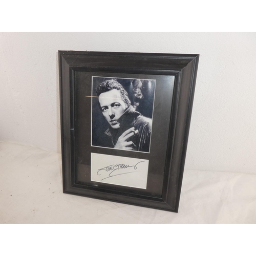 275 - A framed photograph and autograph of Joe Strummer of the Clash.