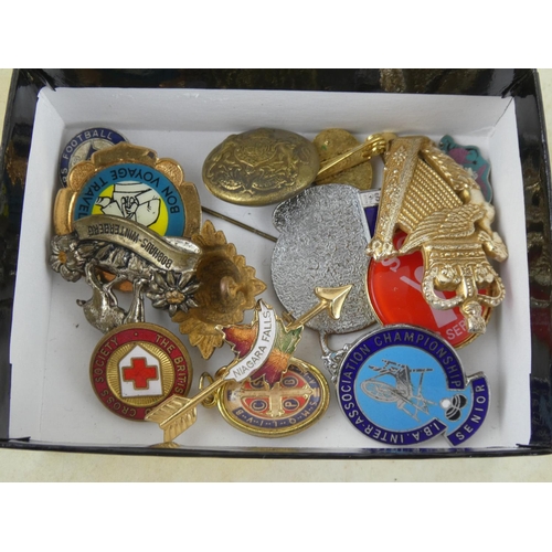 132 - A collection of assorted badges and brooches.