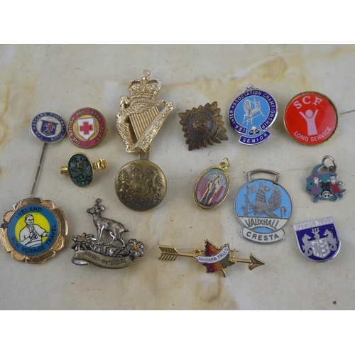 132 - A collection of assorted badges and brooches.