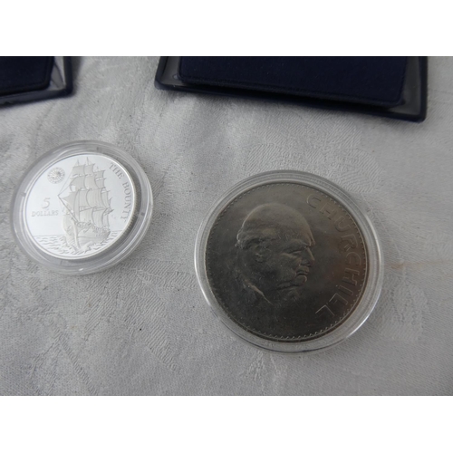 104 - Two Westminster Collection coins 'The Bounty' and 'Churchill' and an old Irish 50p coin.