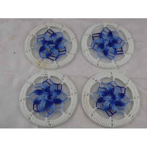 64 - A set of four vintage embroidered coasters.