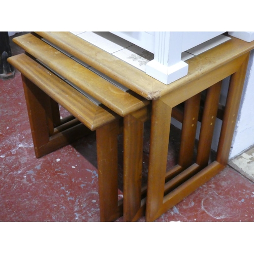 82 - A set of three vintage tiled topped nest of tables.