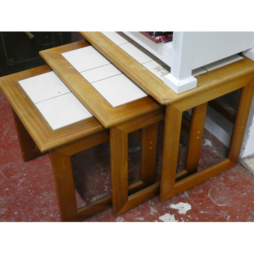 82 - A set of three vintage tiled topped nest of tables.