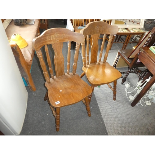 469 - A pair of wooden kitchen chairs with carved detail.