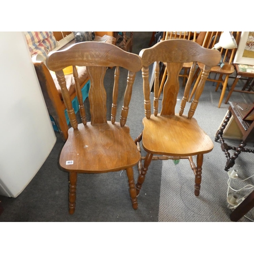 469 - A pair of wooden kitchen chairs with carved detail.