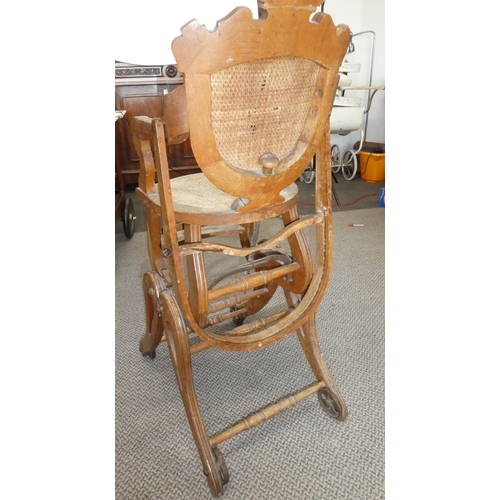 481 - A stunning antique oak high chair on cast iron rollers.