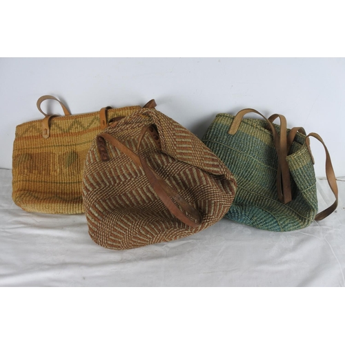 511 - A lot of three hessian bags with leather straps.