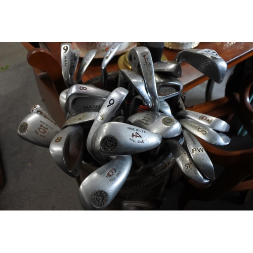 516 - A  set of golf clubs in a brown leather golf bag.