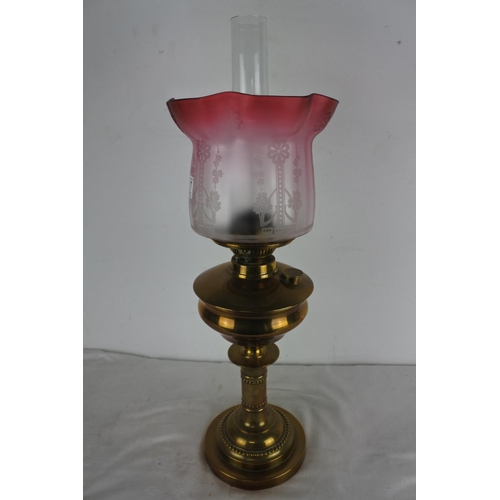 517 - An antique brass based oil lamp and etched glass shade.