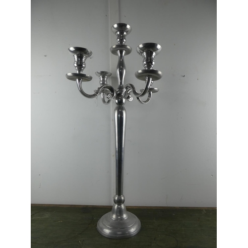 561 - A large silver metal four branch candelabra, measuring 78cm tall.