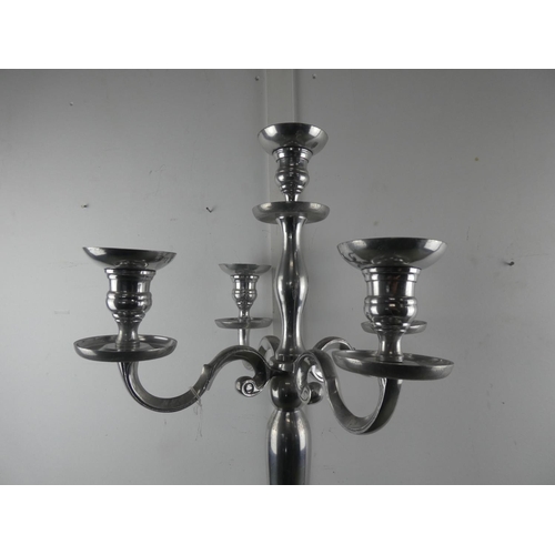 561 - A large silver metal four branch candelabra, measuring 78cm tall.