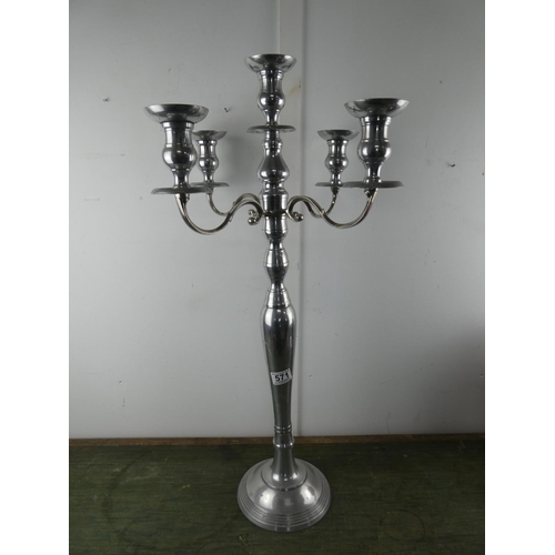 571 - A tall silver metal four branch candelabra, measuring 78cm tall.