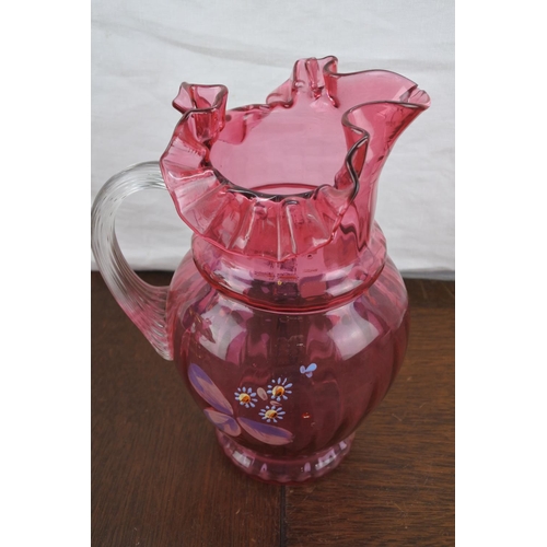 65 - A large antique ruby glass jug with hand painted floral detail (a/f).