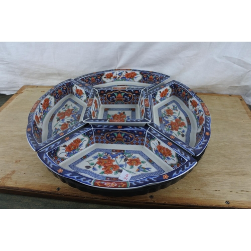 92 - A set of five oriental style serving dishes on a swivel stand.