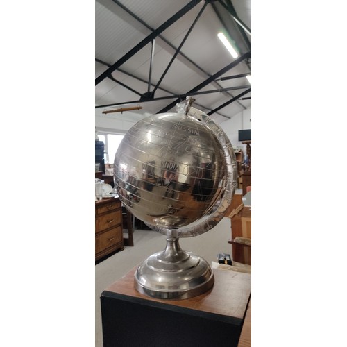 580 - A large silver effect globe on stand, measuring 52cm tall.