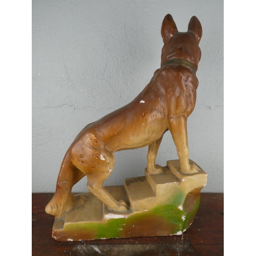 115 - A large chalkware figurine of an Alsatian dog, measuring 45cm tall.
