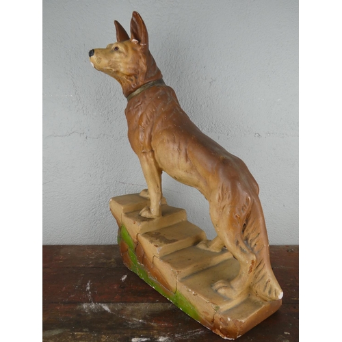 115 - A large chalkware figurine of an Alsatian dog, measuring 45cm tall.
