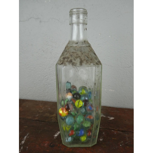 116 - A collection of vintage marbles in a glass bottle.