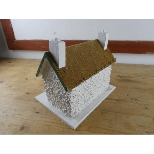 155 - A handmade Irish cottage on a wooden display.