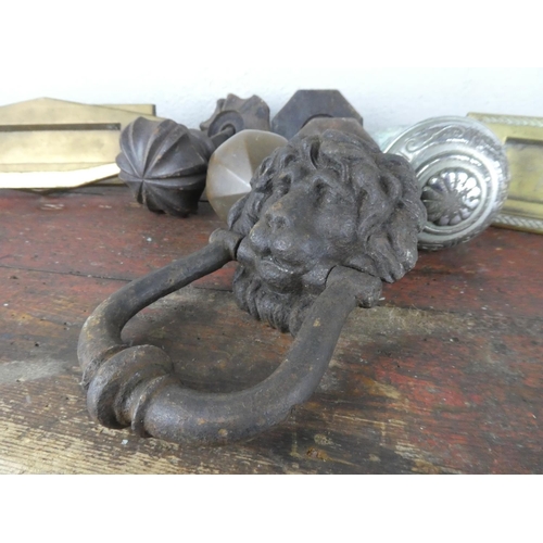 63 - An assorted lot of door knobs, letter boxes and a lion head door knocker.