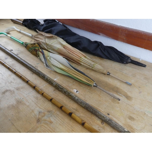 217 - A collection of walking sticks, umbrellas and more.