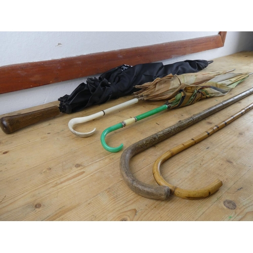 217 - A collection of walking sticks, umbrellas and more.