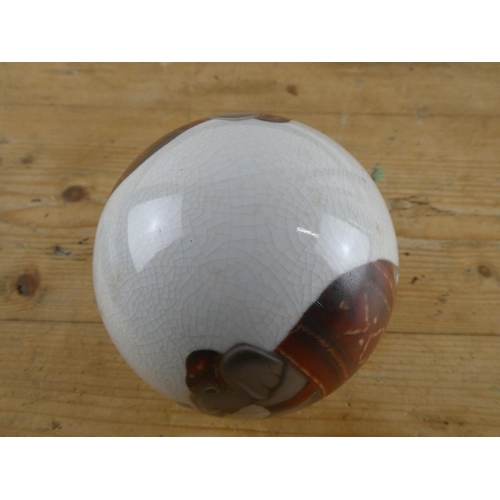 281 - A ceramic ball with elephant design.