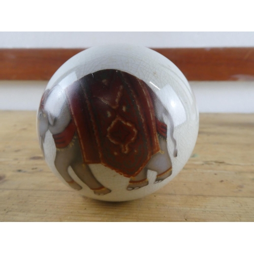 281 - A ceramic ball with elephant design.