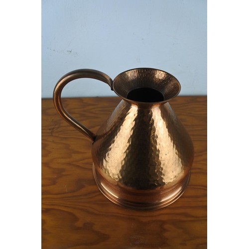 101 - A large copper flagon/ jug, measuring 26cm tall.