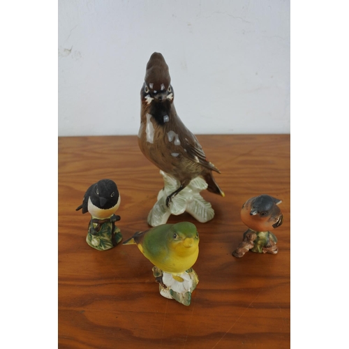 102 - A large glazed Goebel bird figurine and three Beswick bird figurines.