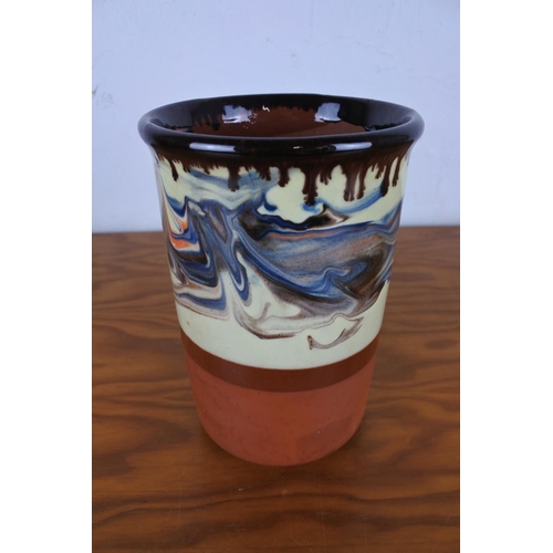 129 - A studio pottery terracotta and glazed utensil pot, measuring 18cm tall.