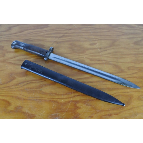 152 - A bayonet in scabbard, measuring 44cm long.