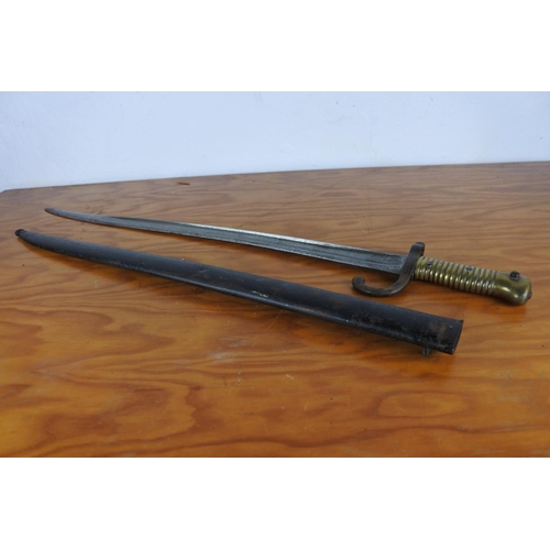 160 - A bayonet in scabbard, measuring 70cm long.