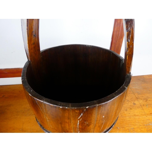 241 - A stunning wooden well bucket with metal fittings, measuring 61cm tall.