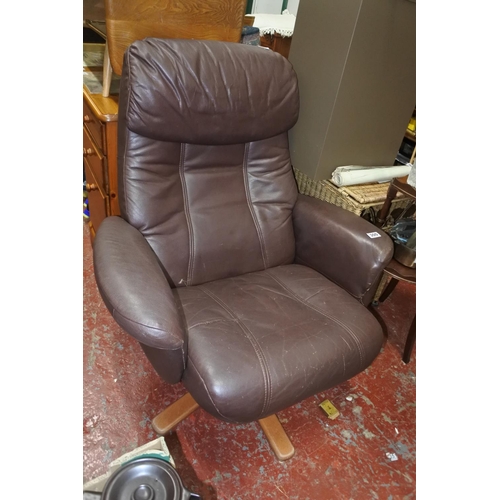 300 - A brown leather swivel lounge chair.