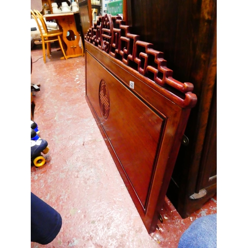 420 - A Chinese rosewood double headboard with oriental design.