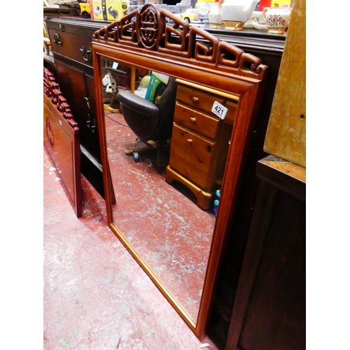 421 - A stunning Chinese rosewood mirror with decoratively carved top, measuring 104cm x 76cm.