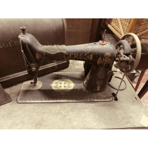 447 - An antique Singer sewing machine on cast iron base and original wooden cover.