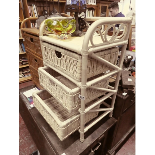 452 - A three drawer wicker storage cabinet.