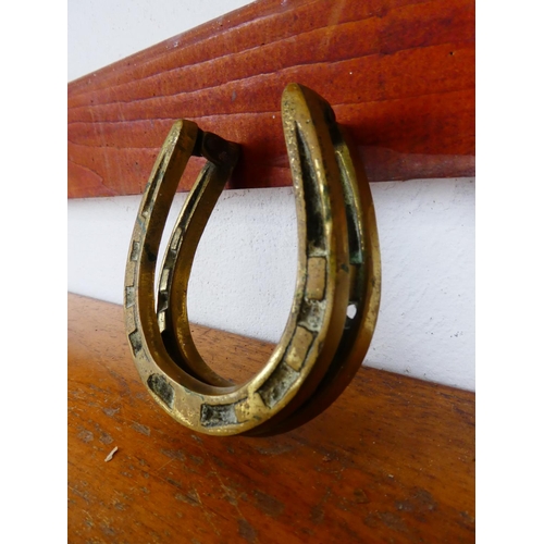 531 - A brass door knocker, modelled as a horse show. Measuring 10cm.