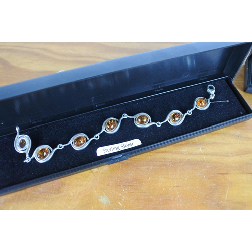 579 - A stunning sterling silver and amber stone bracelet and a Sterling Silver and pendant bracelet.