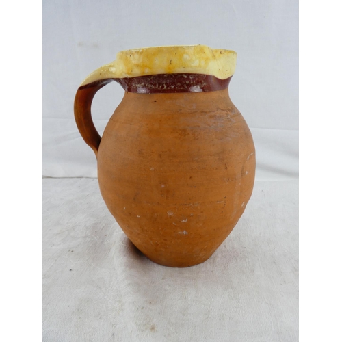 58 - An early 1900's earthenware water jug with brown glaze inside.