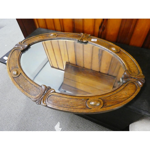 140 - A stunning oak framed oval wall mirror.