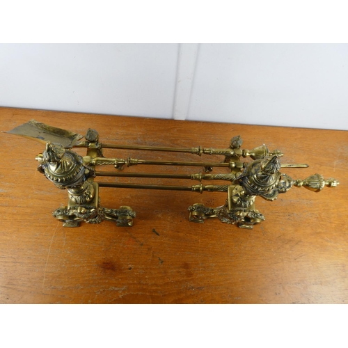 144 - A stunning antique set of heavy brass fire irons and dogs.