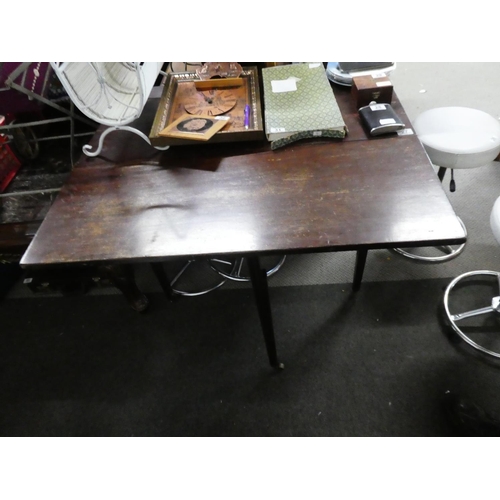 27 - An antique mahogany drop leaf dining table on caster feet.
