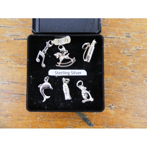 353 - A collection of sterling silver charms.