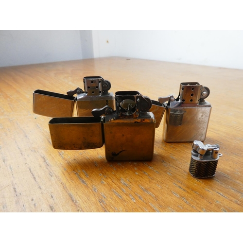 391 - Three vintage Zippo lighters and a miniature lighter.